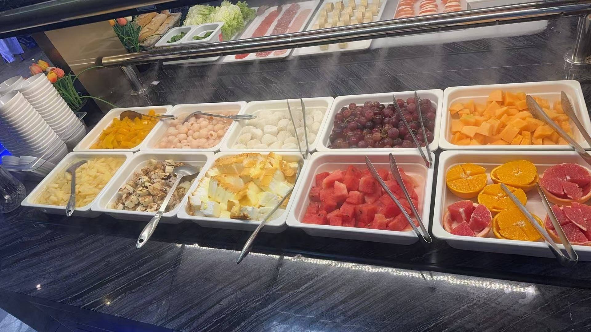 Buffet fruits frais — pastèque, raisins, oranges, melon